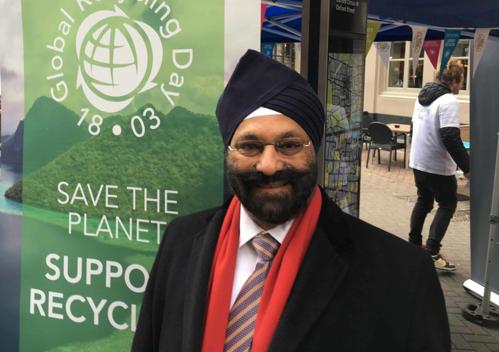 Ranjit S. Baxi beside Global Recycling Day branding at a street event in London