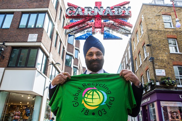 Ranjit S. Baxi holding a Global Recycling Day shirt in Carnaby Street, London